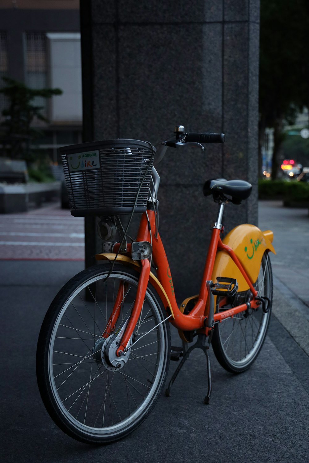 orange city bicycle parked on sidewalk during daytime