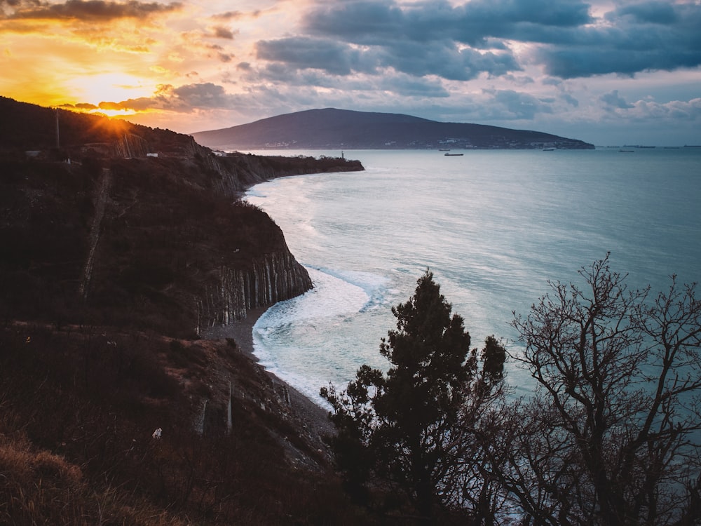 Cuerpo de agua cerca de la montaña durante la puesta del sol