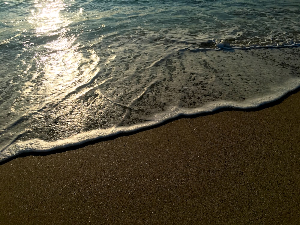 sea waves crashing on shore during daytime