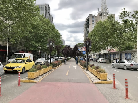 A bustling urban street with modern bike lanes and pedestrian zones.