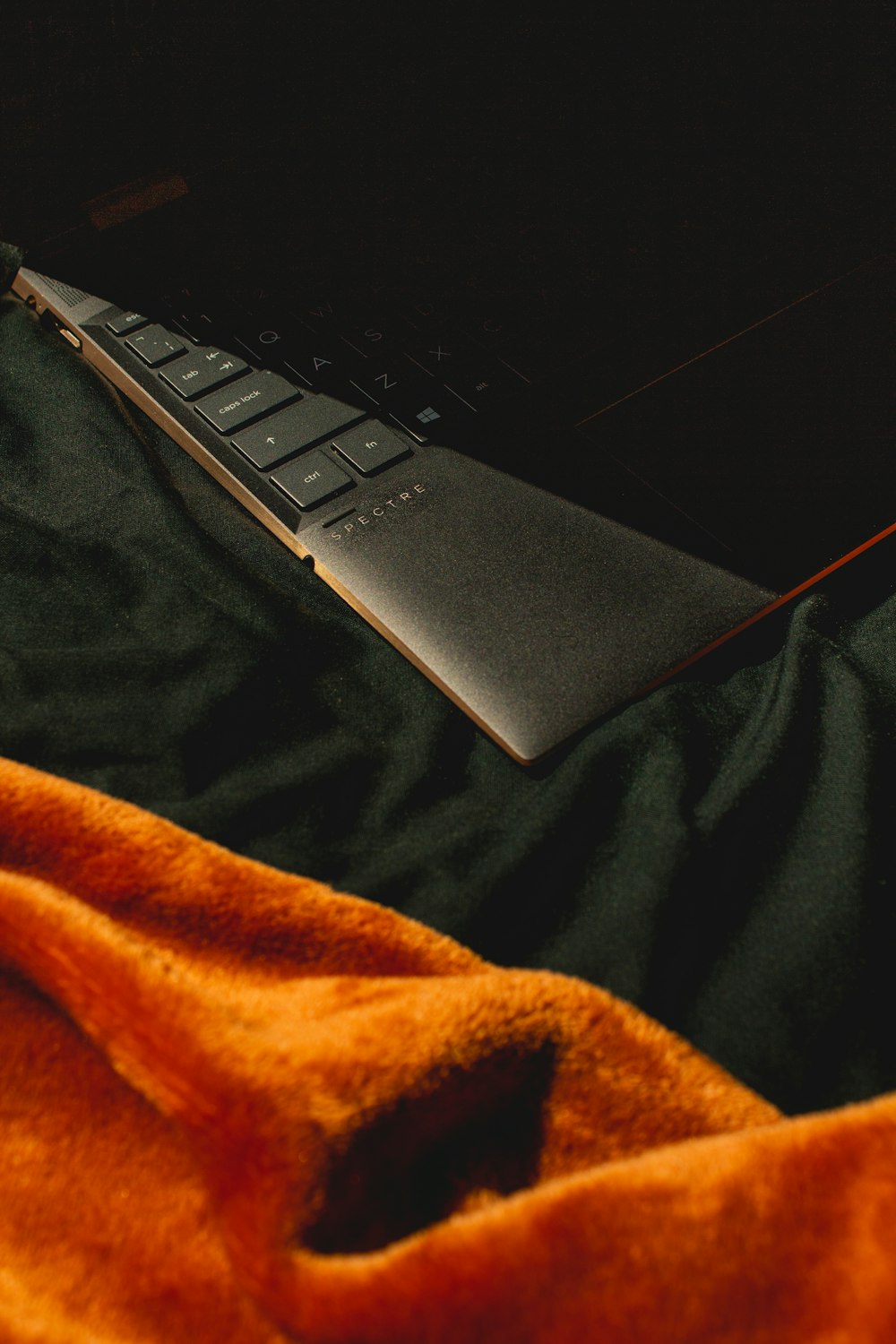 black laptop computer on black and brown textile