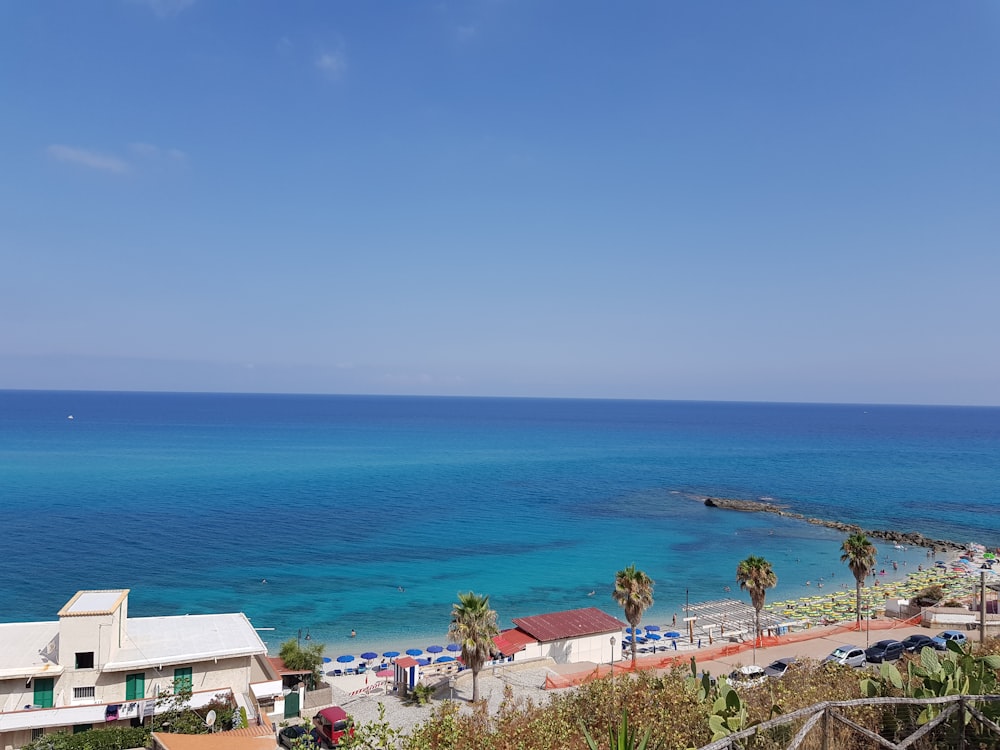 white and brown houses near blue sea under blue sky during daytime