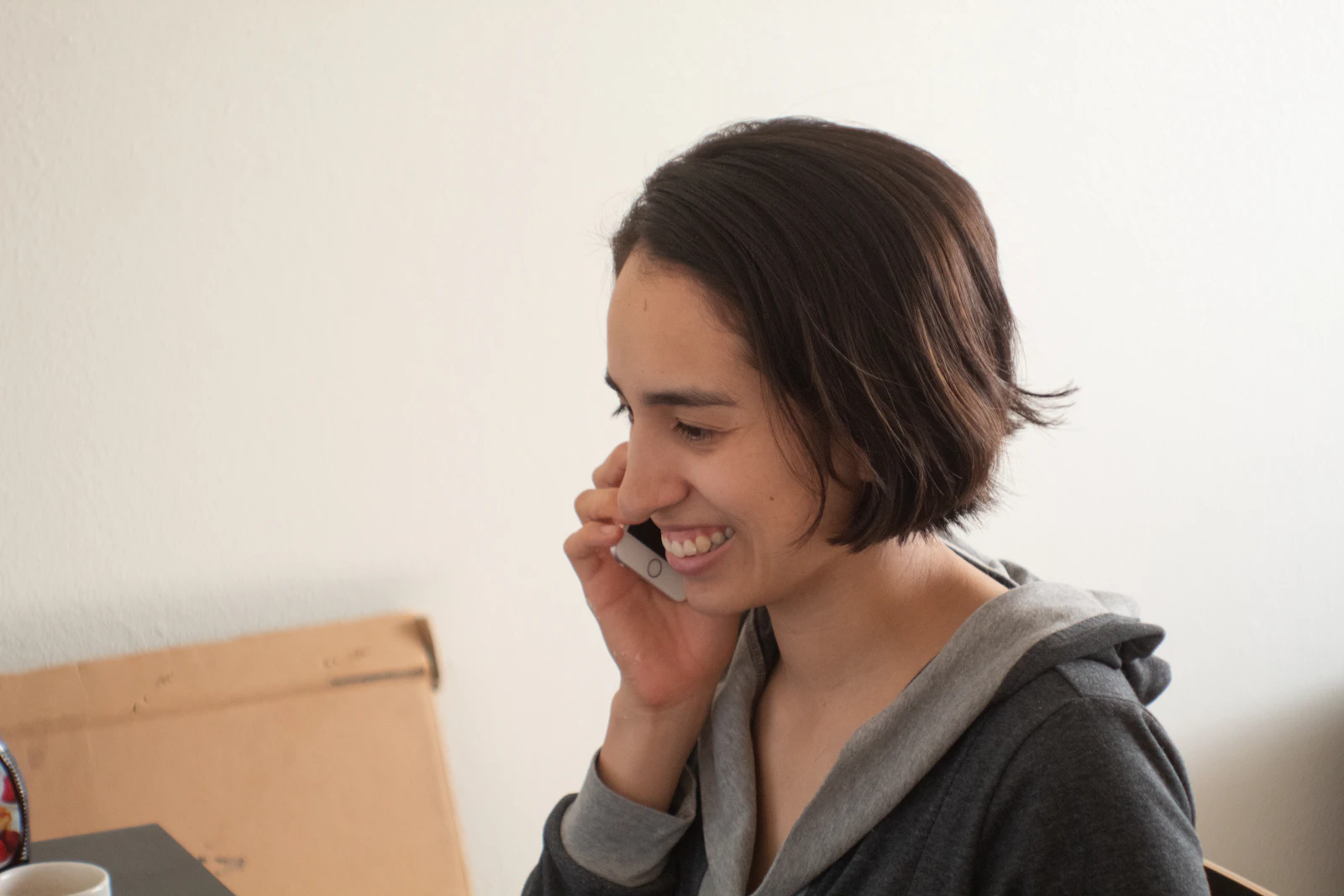 Mujer real sonriendo mientras habla por celular