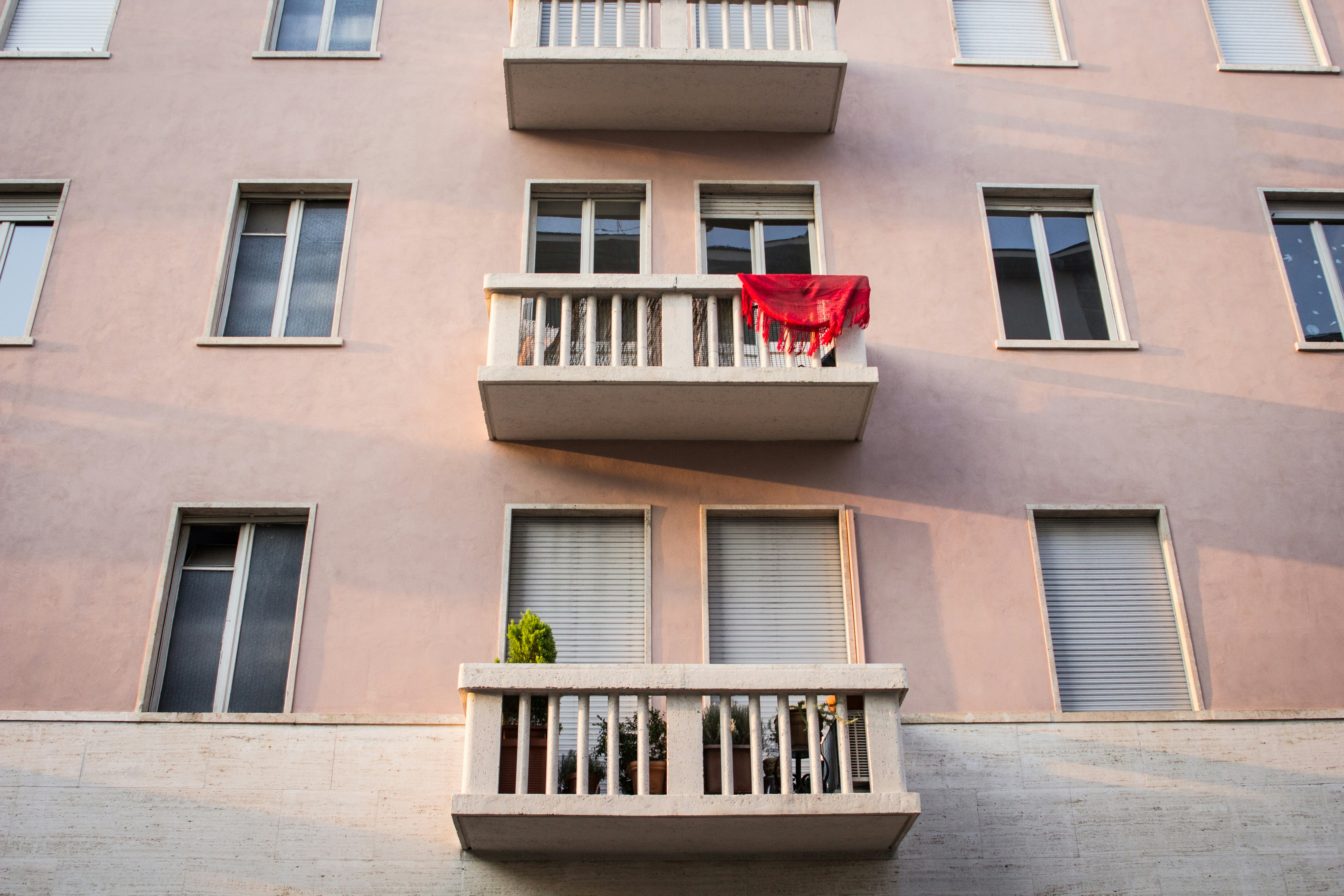 red fabric and green plant on a balcony in Italy