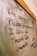 The image displays a message written on a glass or whiteboard with a wooden frame. The message reads 'Dear me, I'm sorry, Please forgive me, I love you, Thank you' with further instructions to repeat it. There is also a small decorative symbol on the right side.