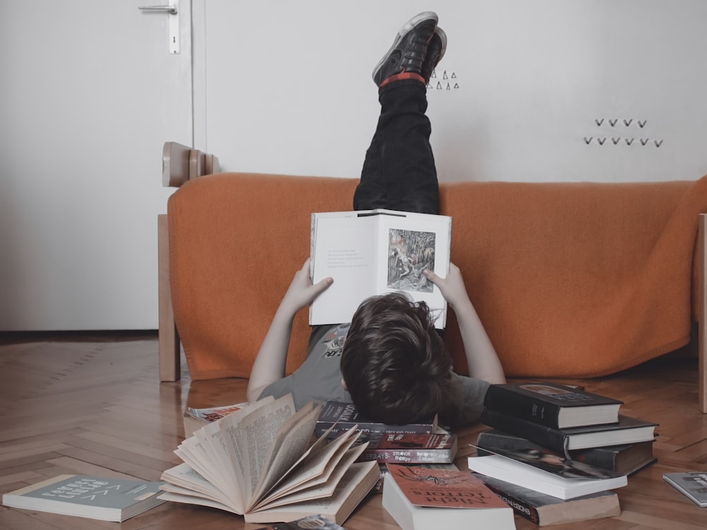 woman reading book on orange sofa