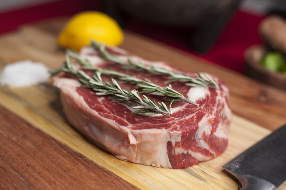 raw meat on brown wooden chopping board