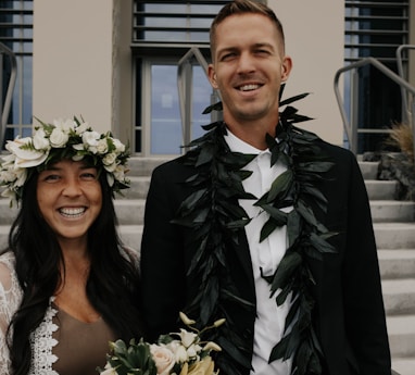 woman in white floral wedding dress beside man in black suit