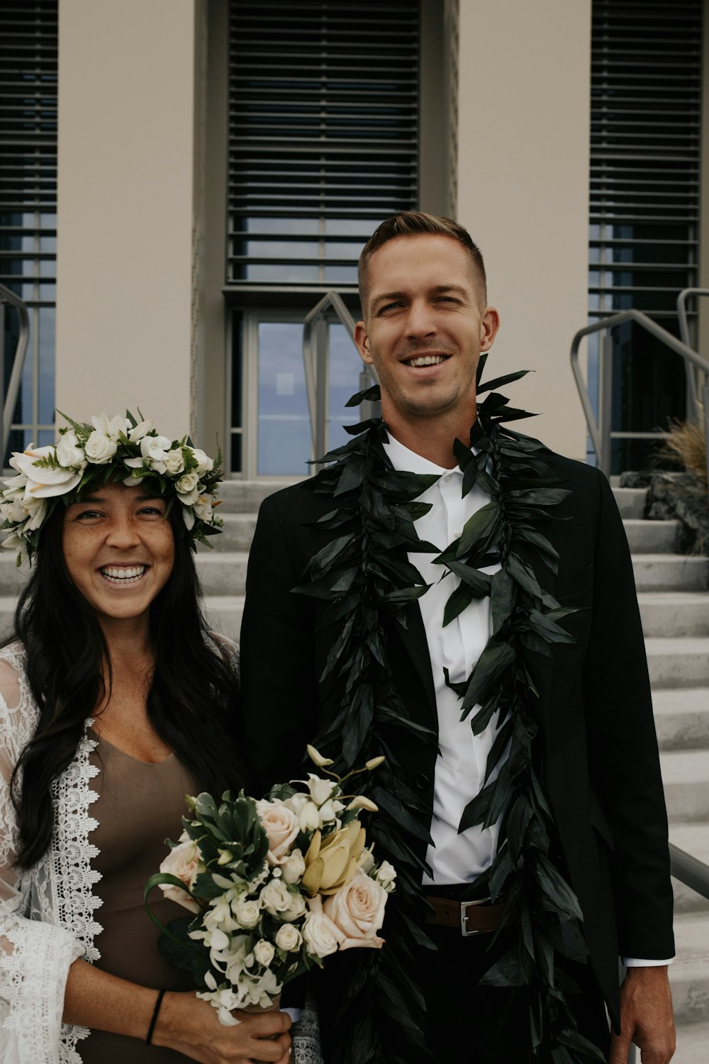 woman in white floral wedding dress beside man in black suit