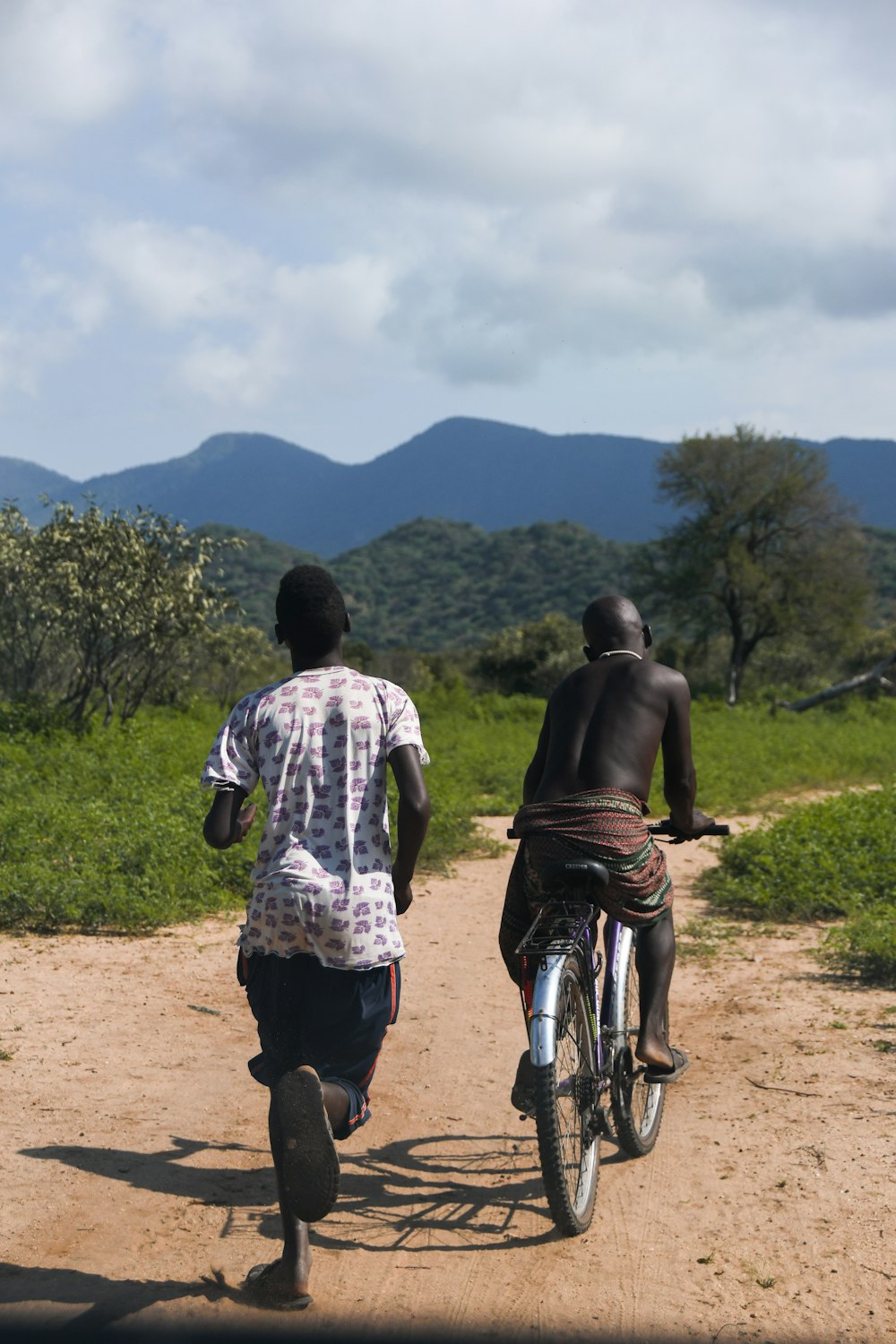 2 men walking on dirt road during daytime