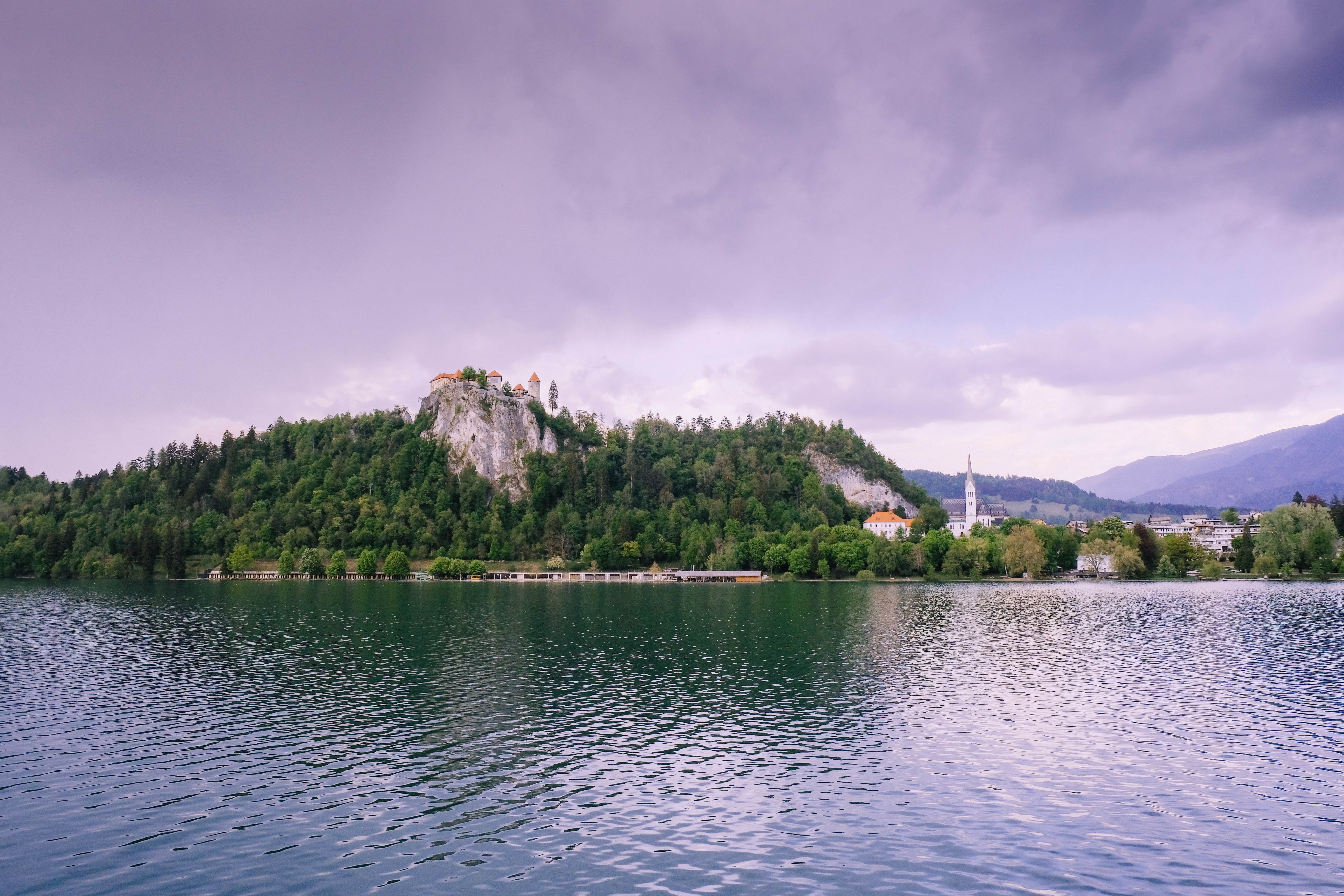 green trees on island surrounded by water under blue sky during daytime