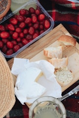 fresh cheese with fruit and bread on a wooden board