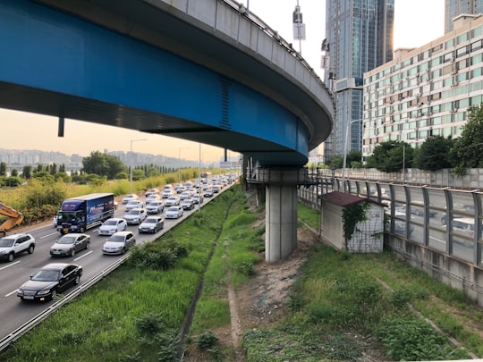 cars parked on parking lot near blue bridge during daytime in Ichon-dong South Korea