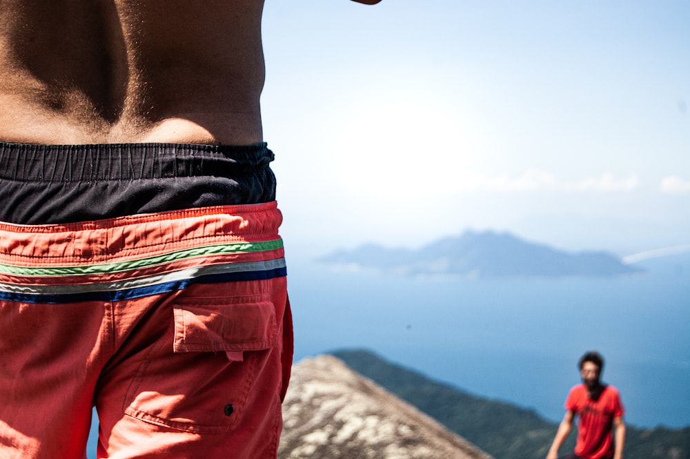 man in red and black shorts raising his right hand