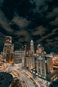 city buildings under dark clouds during night time