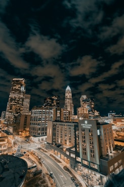 city buildings under dark clouds during night time