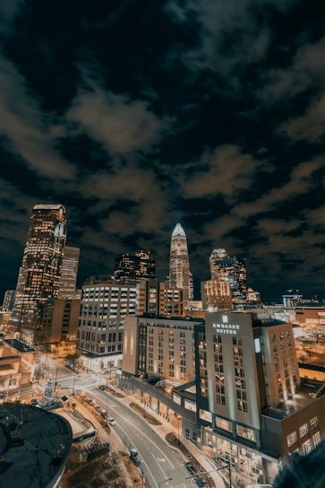 city buildings under dark clouds during night time
