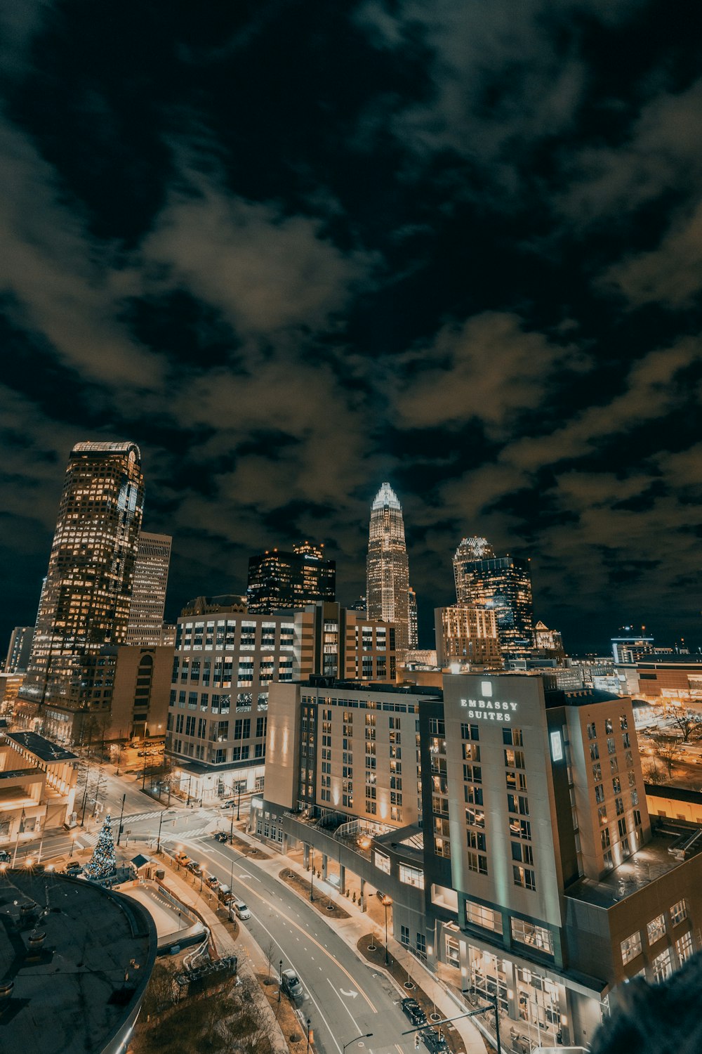 city buildings under dark clouds during night time