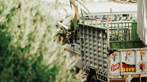 Workers installing colorful vehicle wraps on trucks outside an industrial makeup plant in Sinaloa.