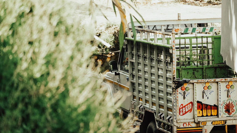 A vibrant truck wrapped with colorful advertising graphics driving through the streets of Constanța under a clear blue sky.