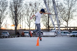 man in white shirt and gray pants jumping on gray concrete floor