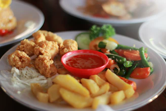 fried chicken and fries on white ceramic plate