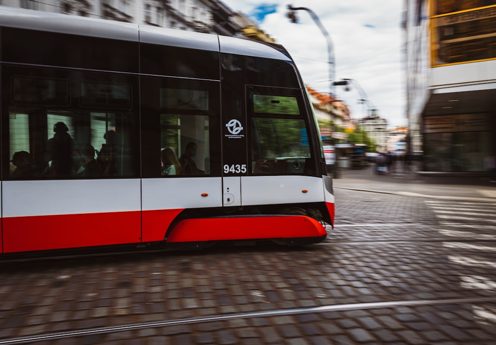 trem vermelho e branco na estrada de ferro durante o dia