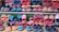 A variety of colorful, handcrafted shoes arranged in neat rows. The shoes display intricate patterns and vibrant colors such as red, blue, orange, and black. Some feature detailed embroidery or unique designs, highlighting artisanal craftsmanship.