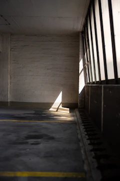 A neatly cleared garage with sunlight streaming in, showing a freshly cleaned space ready for use.