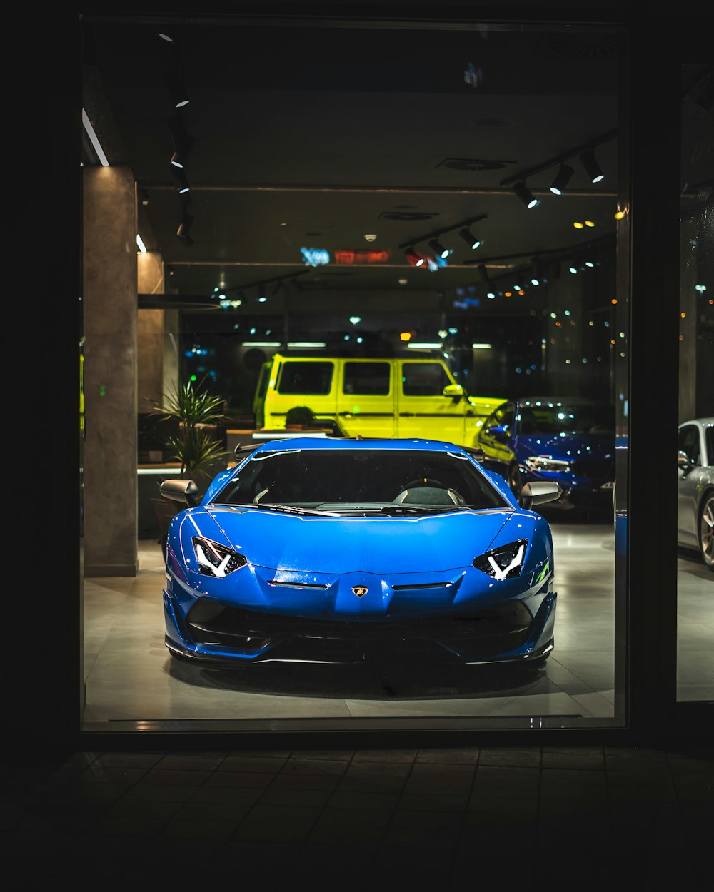 blue bmw m 3 parked on sidewalk during night time