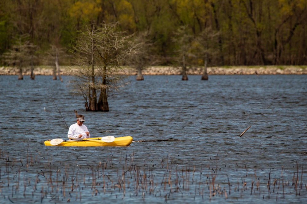 person riding yellow kayak on river during daytime