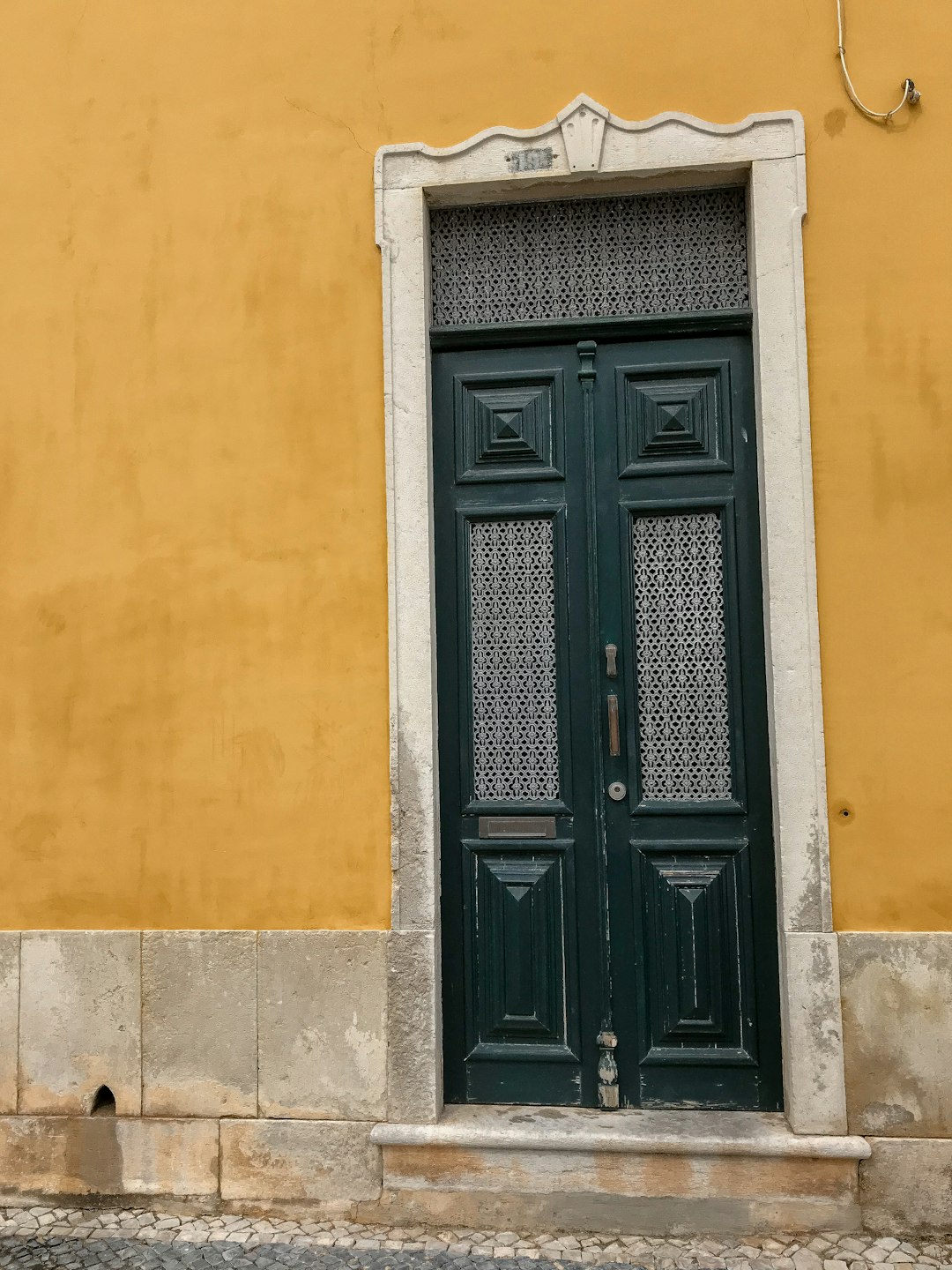 black wooden door on yellow concrete wall
