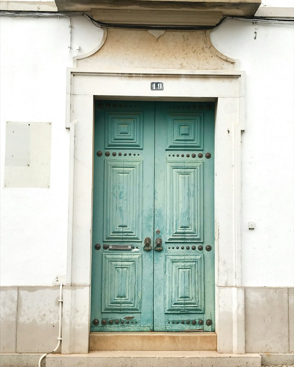 blue wooden door on white concrete wall