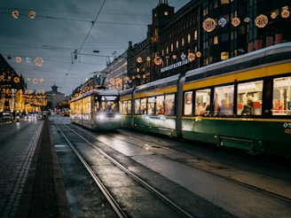 green and white tram on the street during night time