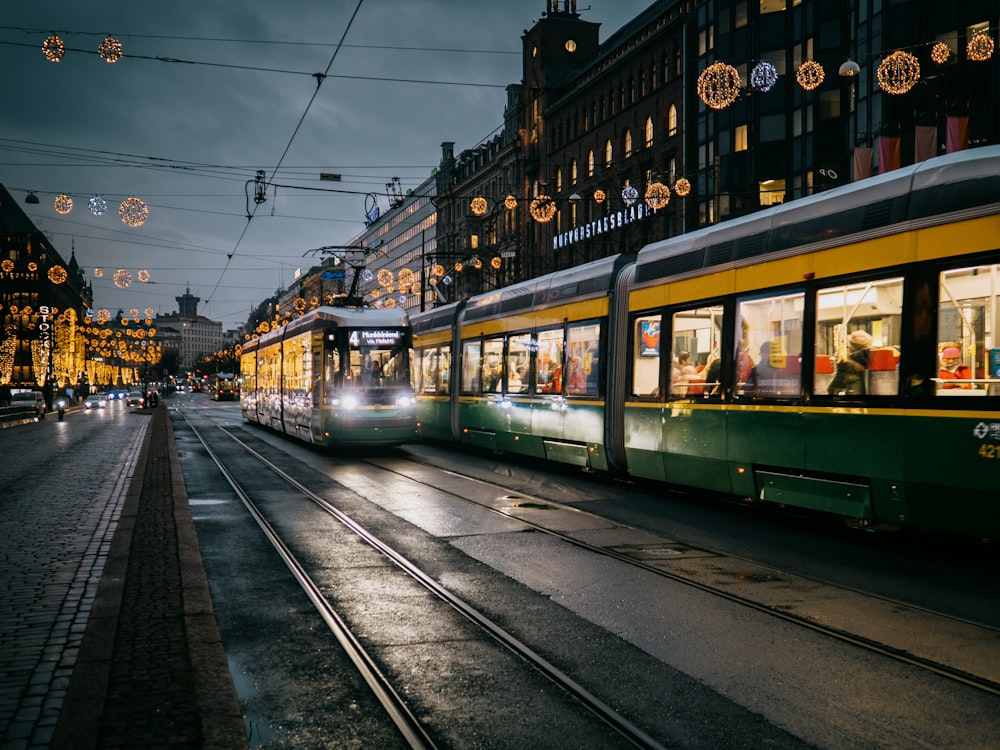 green and white tram on the street during night time