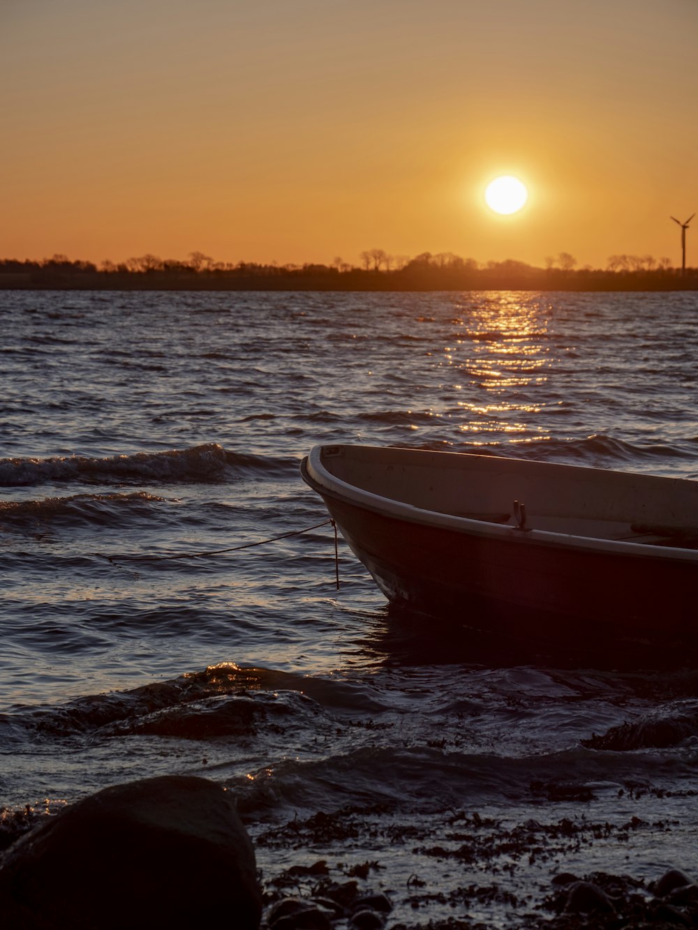 barco branco e marrom no mar durante o pôr do sol