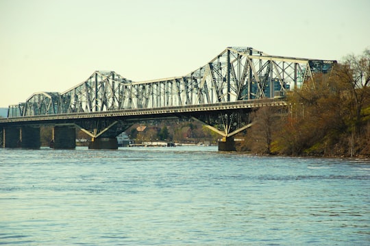 gray metal bridge over body of water during daytime in Jacques Cartier Park Canada