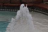 Close-up of crystal clear water flowing from a pool fountain.