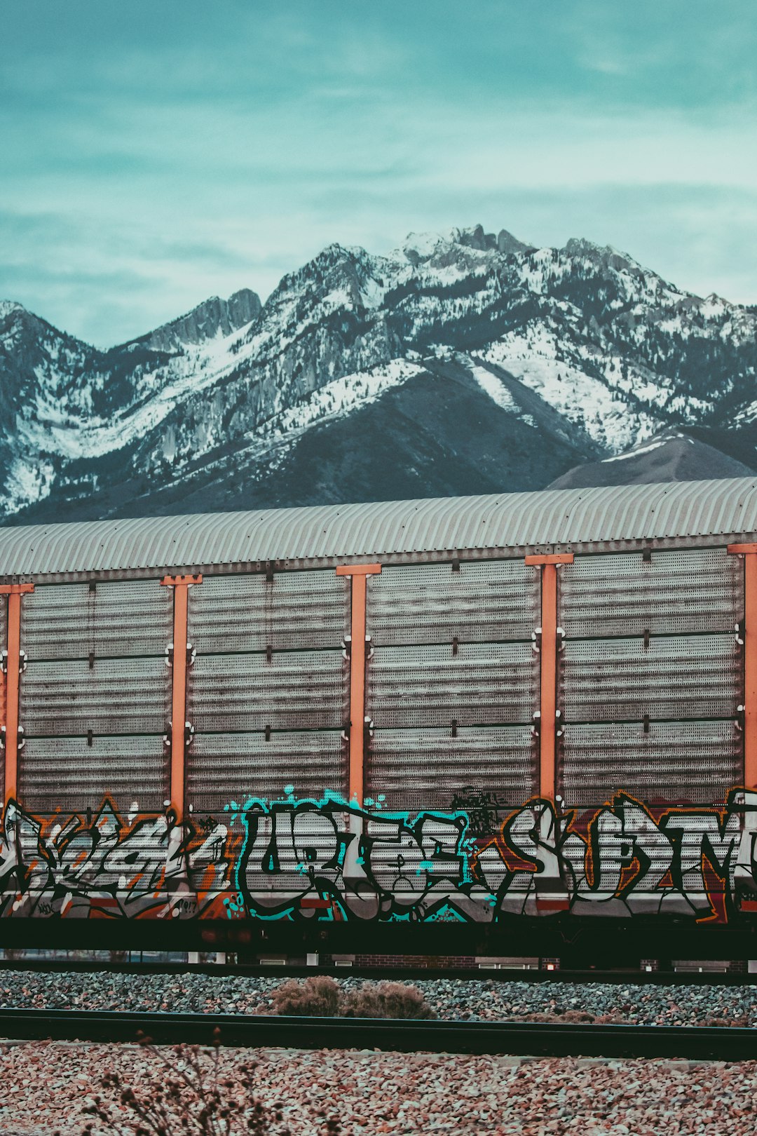 brown wooden house near snow covered mountain during daytime