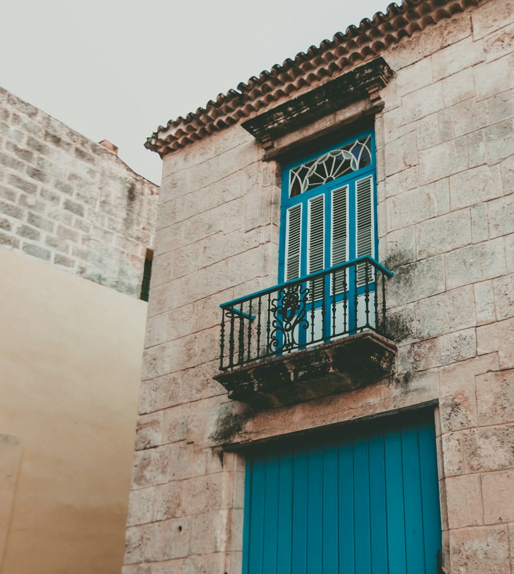 blue wooden window on white concrete building during daytime