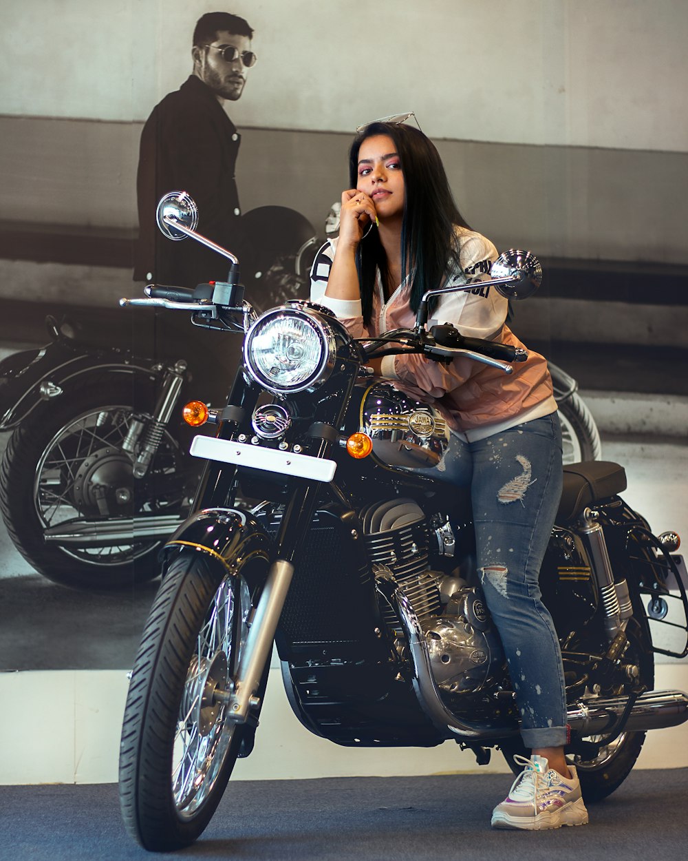 woman in black leather jacket and blue denim jeans riding black cruiser motorcycle