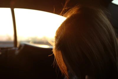 A serene morning scene with sunlight streaming through a car window, highlighting a parfumée diffuser.