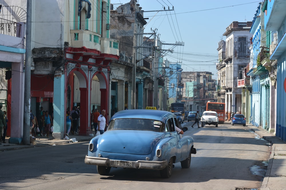 blue classic car on road near building during daytime