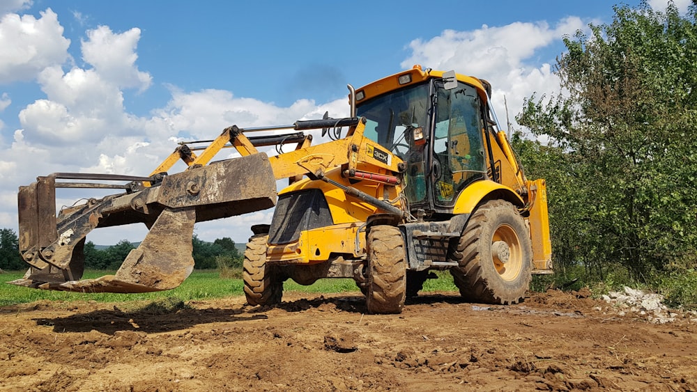 yellow and black heavy equipment on brown field during daytime