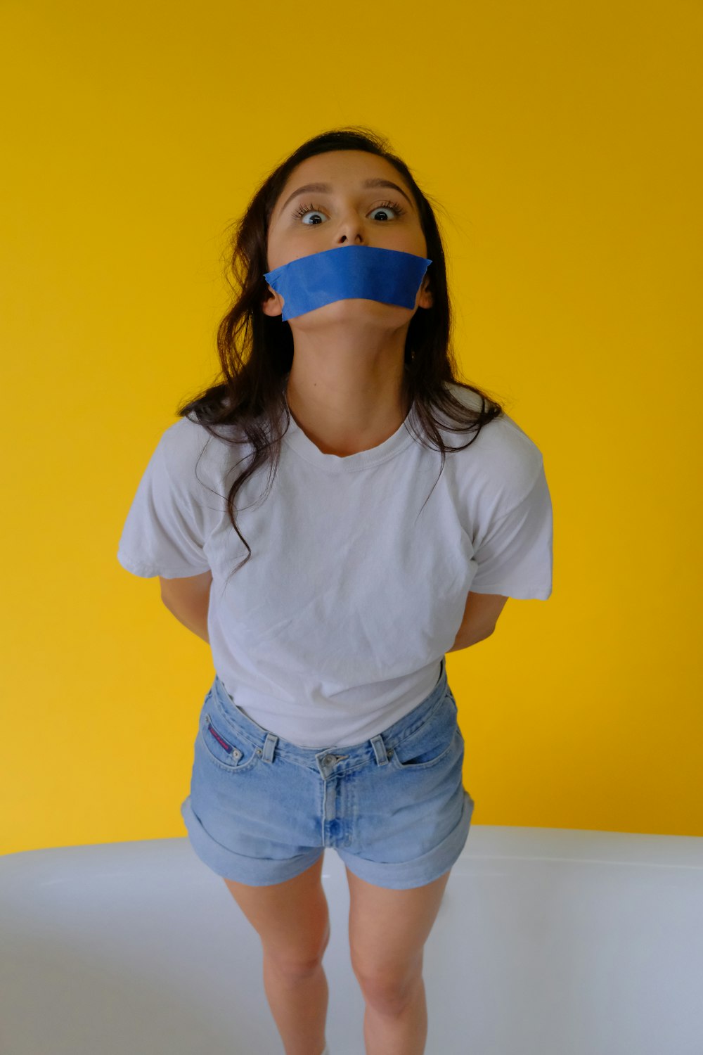 girl in white crew neck t-shirt and blue denim shorts