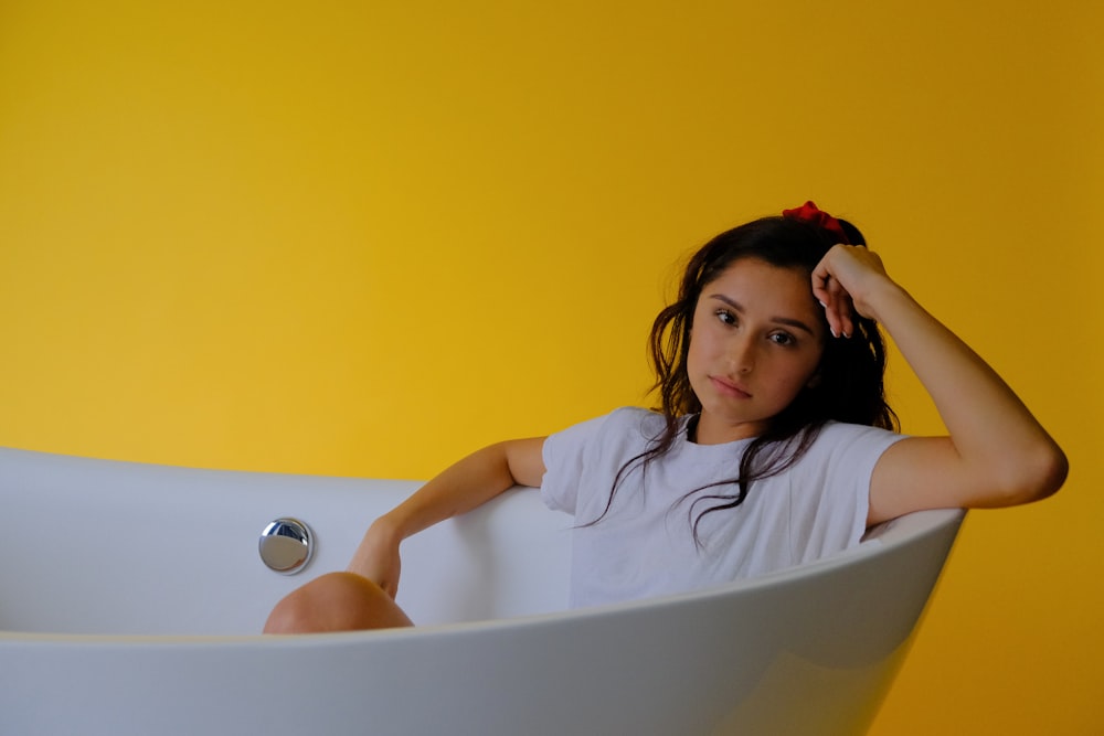girl in white crew neck t-shirt on white bathtub