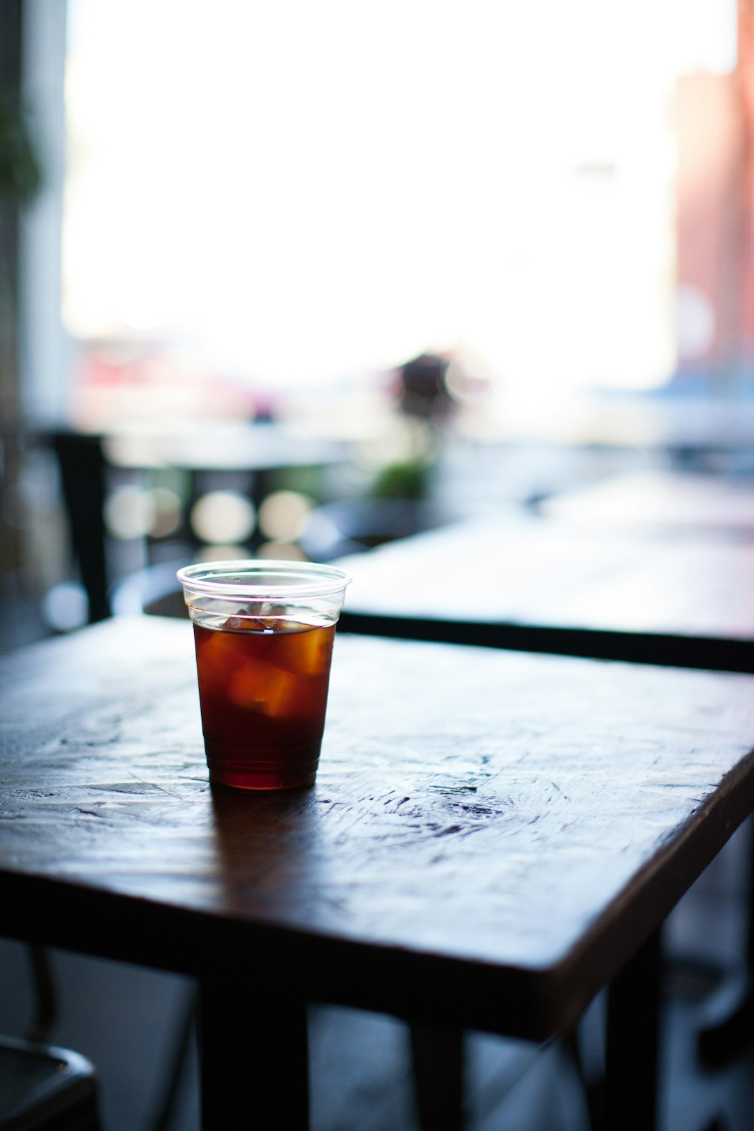 clear shot glass on brown wooden table