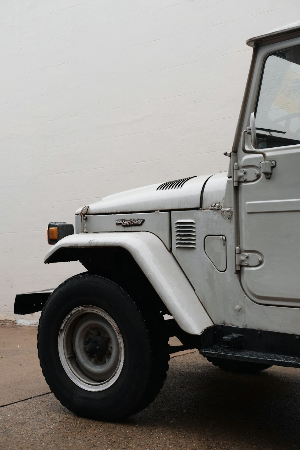 grey truck parked near white wall