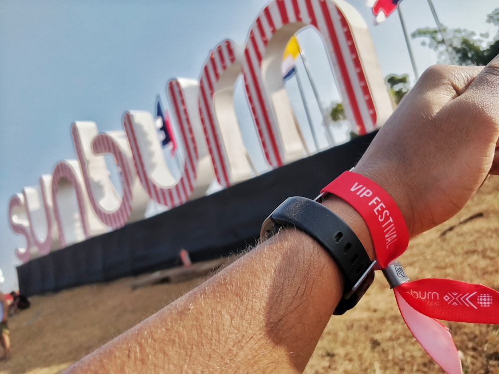 person wearing black and red silicone bands