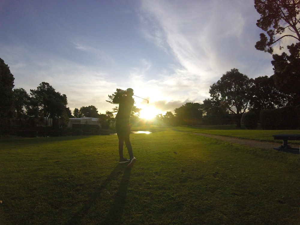 person standing on green grass field during daytime